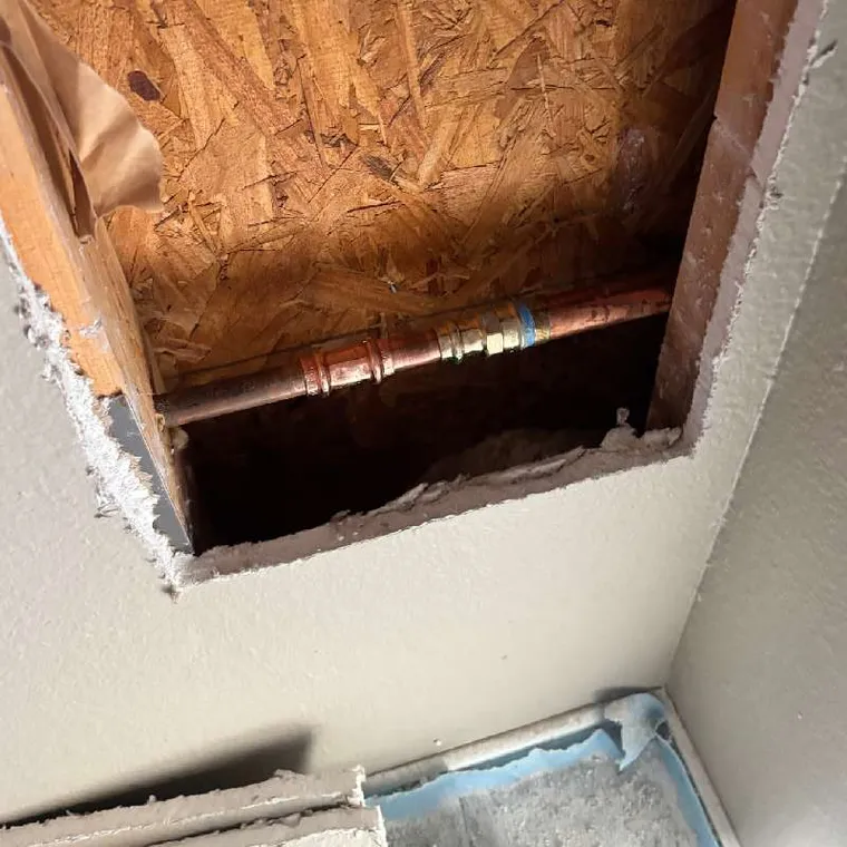 Drywall access panel opened to replace frost-free hose bib stem damaged by freeze break