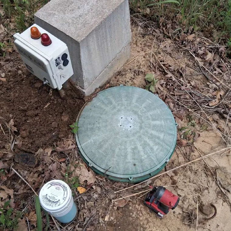 Open aerobic septic tank access with incoming pipe during True Septic service near Tahlequah OK