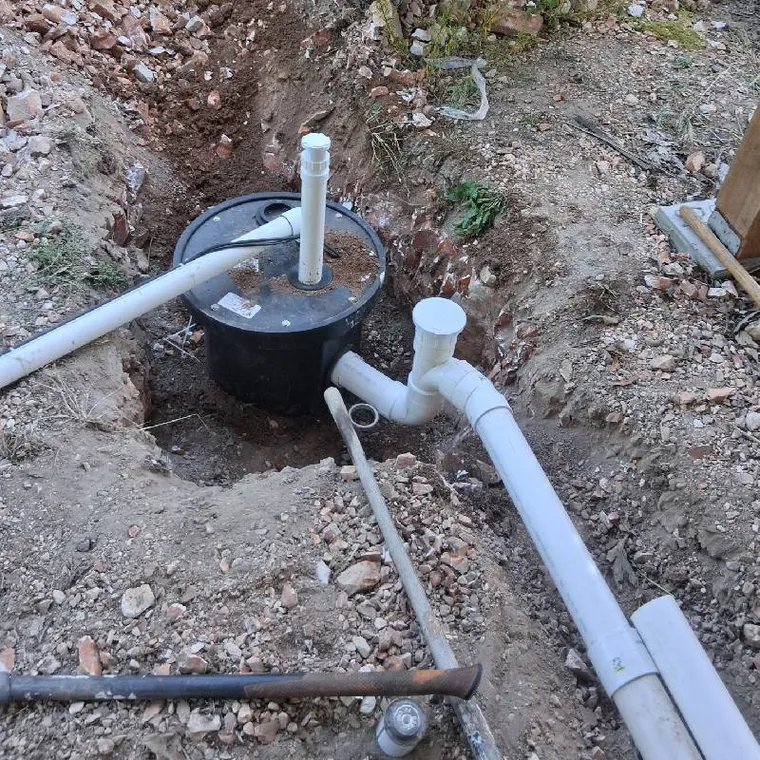 Lift pump basin and sewer piping installed in an excavated area in Stilwell