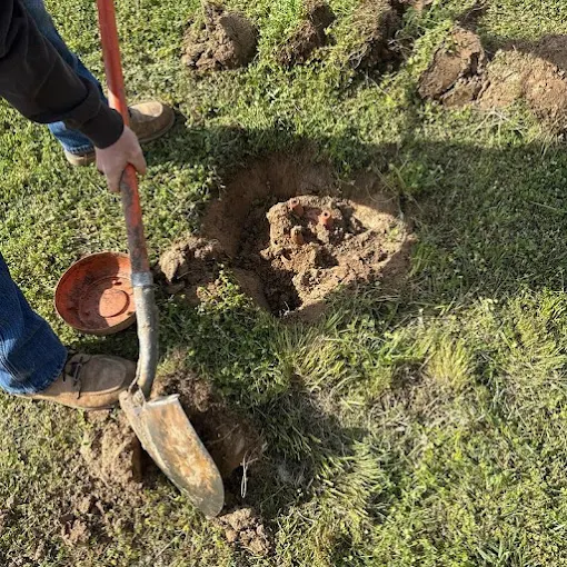 Clog Hunter digging down to a septic tank lid on a rural property