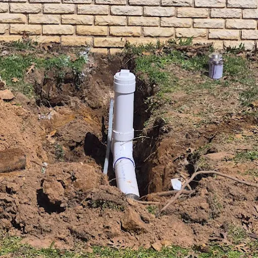 A new PVC sewer cleanout Clog Hunter installed beside a home
