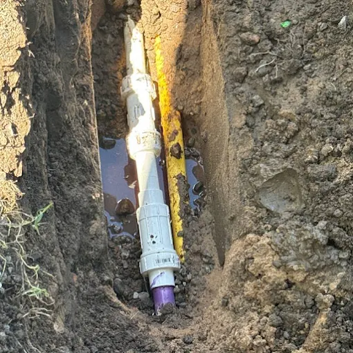 Clog Hunter repairing an underground line in a narrow trench